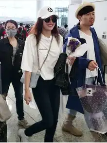 秦岚黑色牛仔半穿内搭白t现身机场造型时尚简约少女气息十足