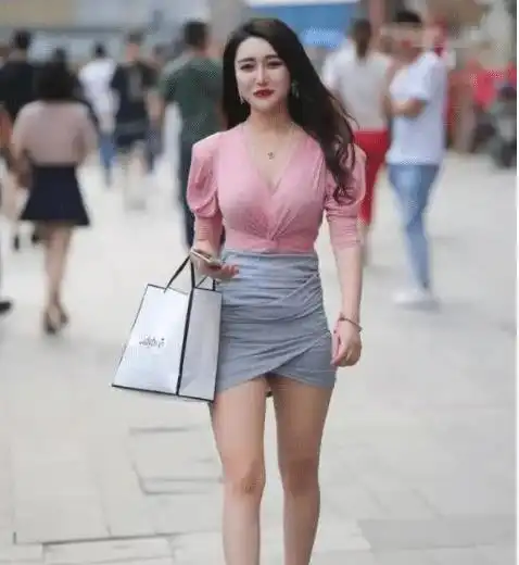 美女在街边吸引了路人们的注意,纷纷驻足观看,搞得美女花容失色