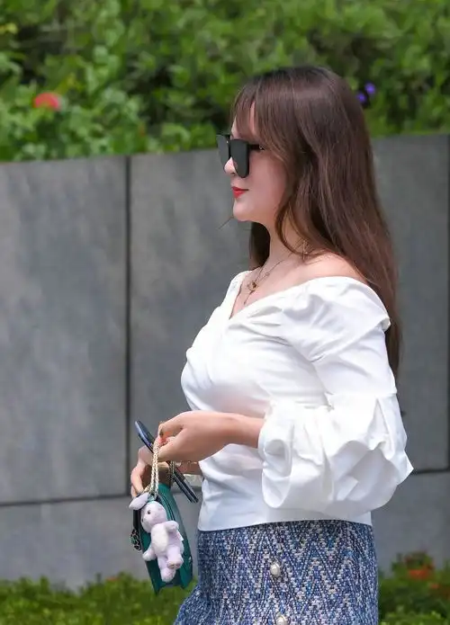 时尚街拍戴一副黑色太阳镜,精致的妆容让美女看起来妩媚感十足