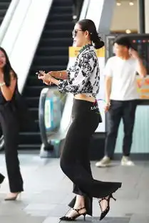 街拍时尚的美女穿印花衬衣搭配黑色喇叭裤出街,霸气侧漏