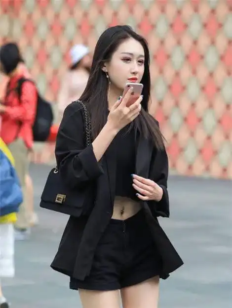 气质街拍皮肤白皙的优雅少妇,身穿黑色西装外套搭配短裤,彰显成熟女性魅力