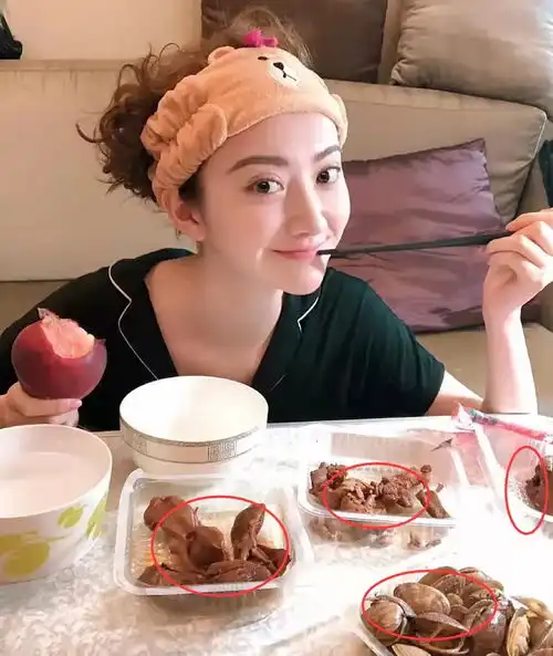 景甜坐在地上吃饭,穿黑色睡衣搭配棕色发箍,桌上食物引发热议