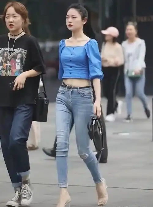 路人街拍,姑娘优雅迷人很吸睛,穿白色的休闲上衣尽显成熟女人味
