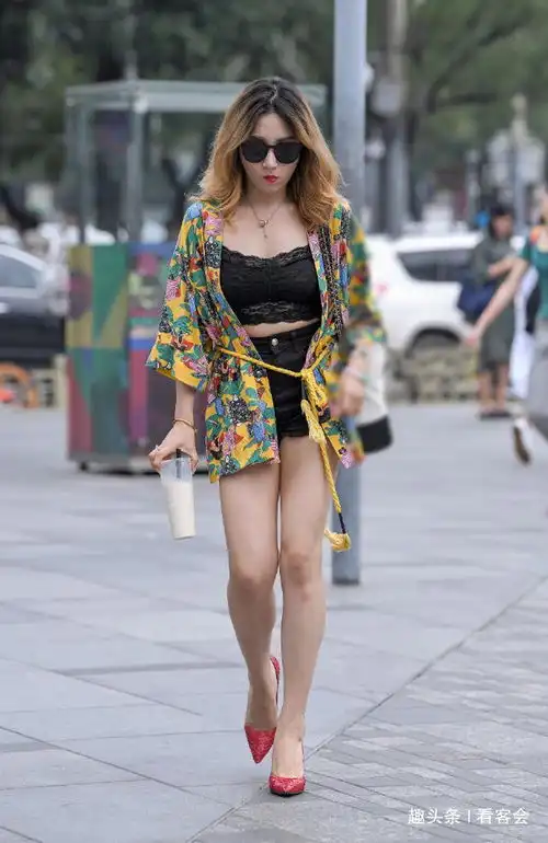 街拍美女戴着墨镜,开衫搭的蕾丝背心,妩媚动人又艳丽