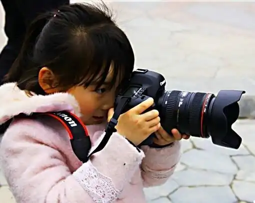 手拿单反相机专注在不同场景中的美女摄影师们41图