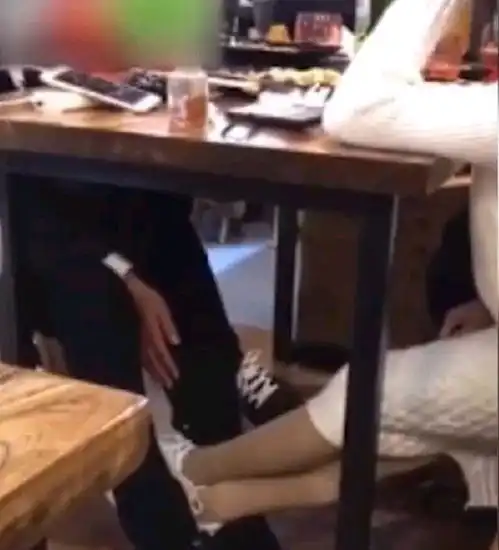 男子搂着女友亲热,右手在桌下抚摸对面女生,三人都很开心