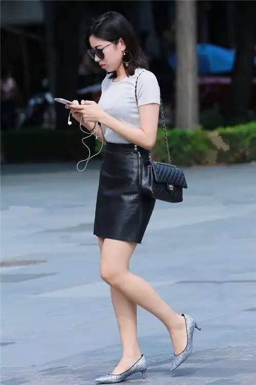 路人街拍,穿着短袖小黑皮裙的美女,戴着墨镜一路玩手机