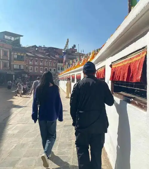 李连杰携妻女拜访佛学院,与俩女儿搂肩合影,步伐稳健精神好